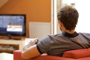 Rear view of young man watching television