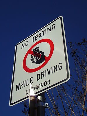 A sign that states "No Texting While Driv...
